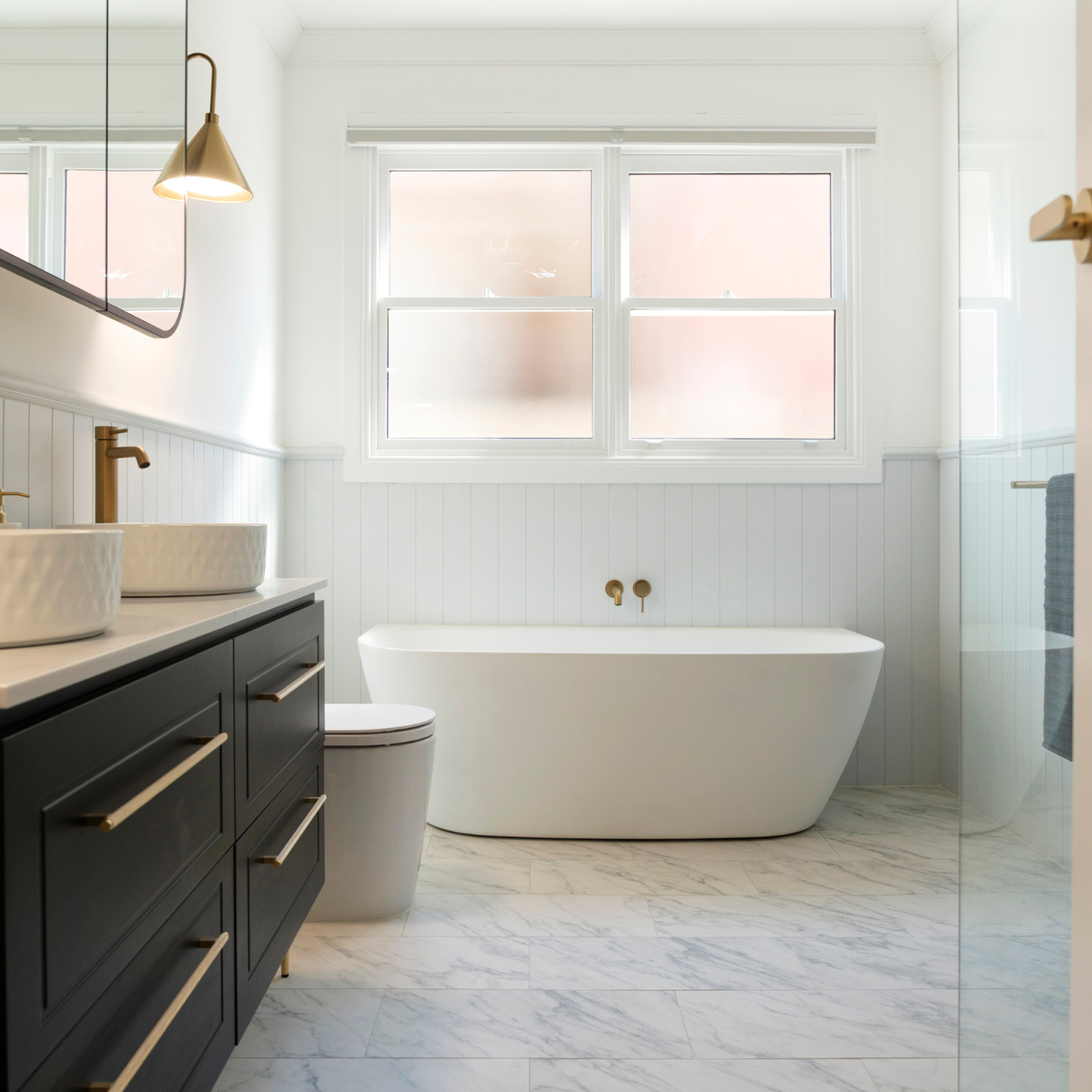 Caroma back to wall bath in marble bathroom setting