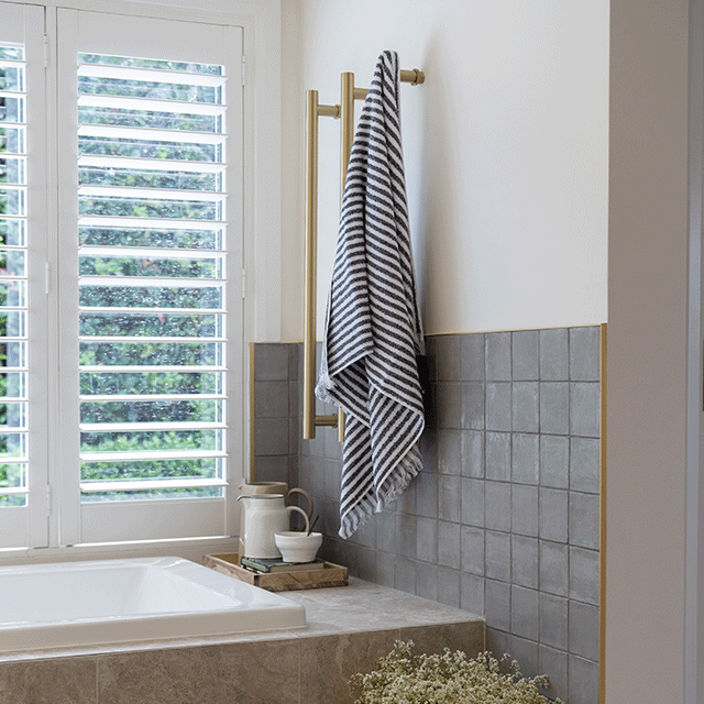 Nickel Grey Dianna Zellige Tile 100 x 100 x 9mm Spanish Ceramic Tile with Phoenix brushed gold heated towel rails and Caroma Newbury island bath